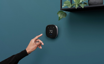 A hand pointing at a wall clock.