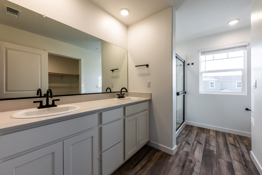 A bathroom with white cabinets.