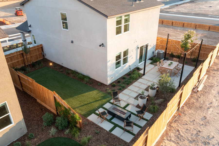 A backyard with a pool and a house.