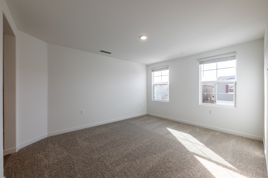 A room with a carpet and windows.