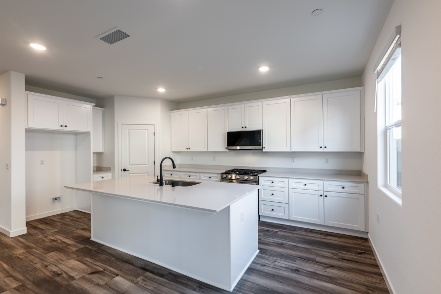 A kitchen with white cabinets.