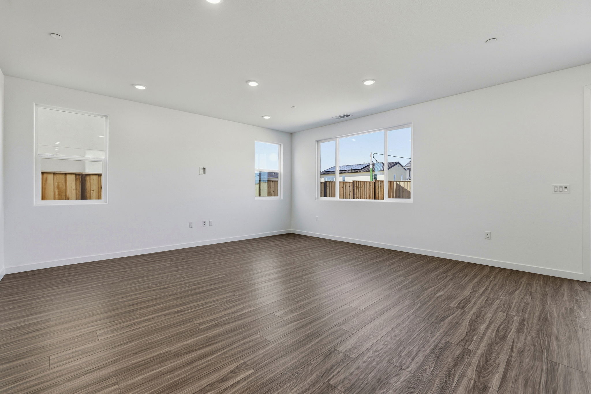 A room with a wood floor and a wood floor with a window.