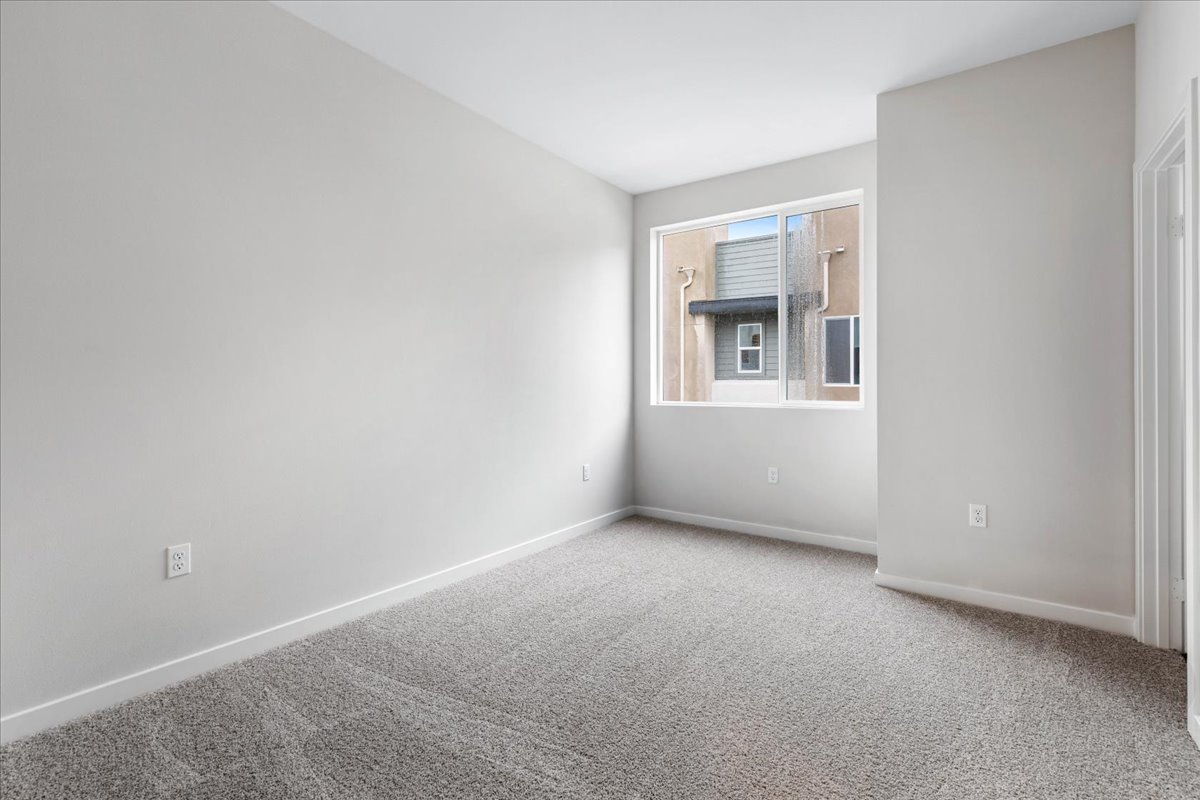 A room with a window and a carpet.