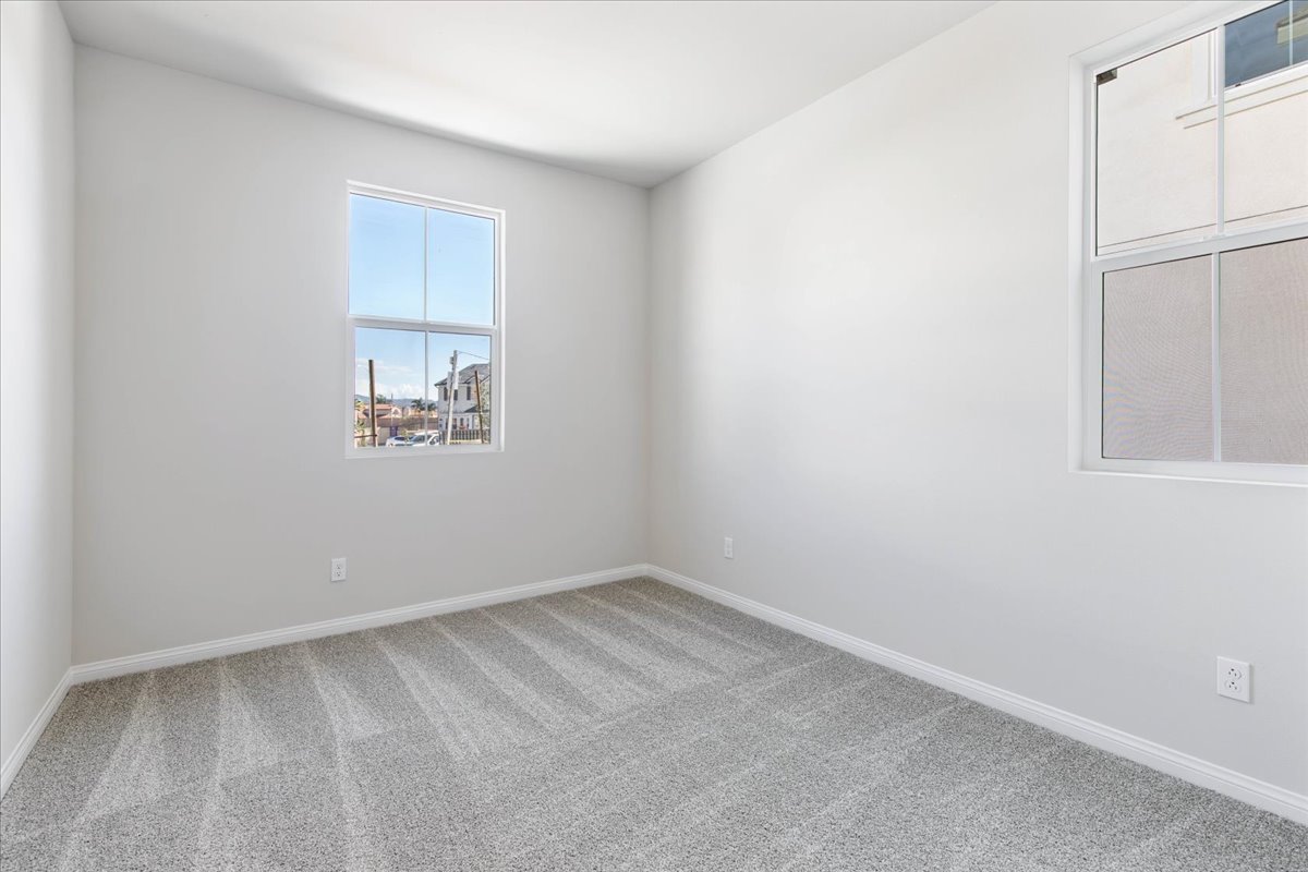 A room with a window and a painting on the wall.