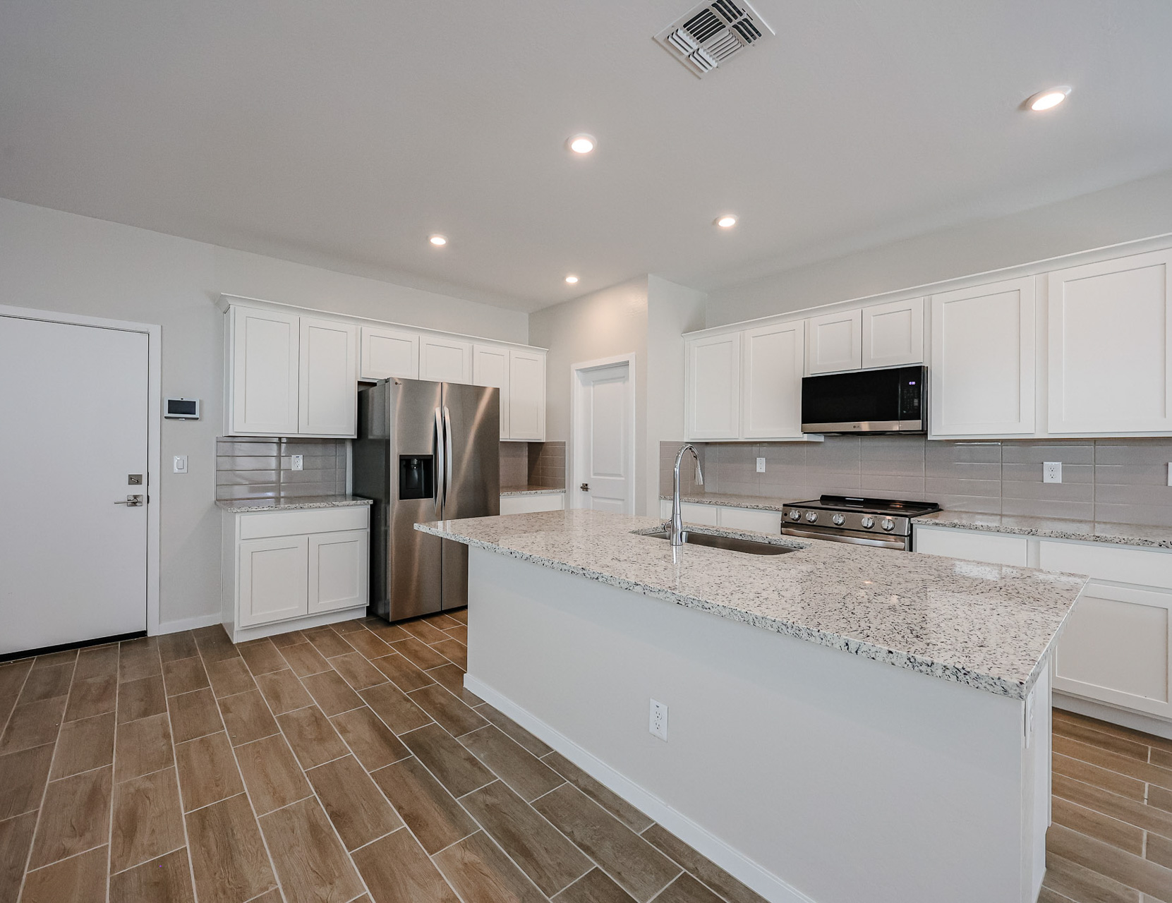 A kitchen with white cabinets.