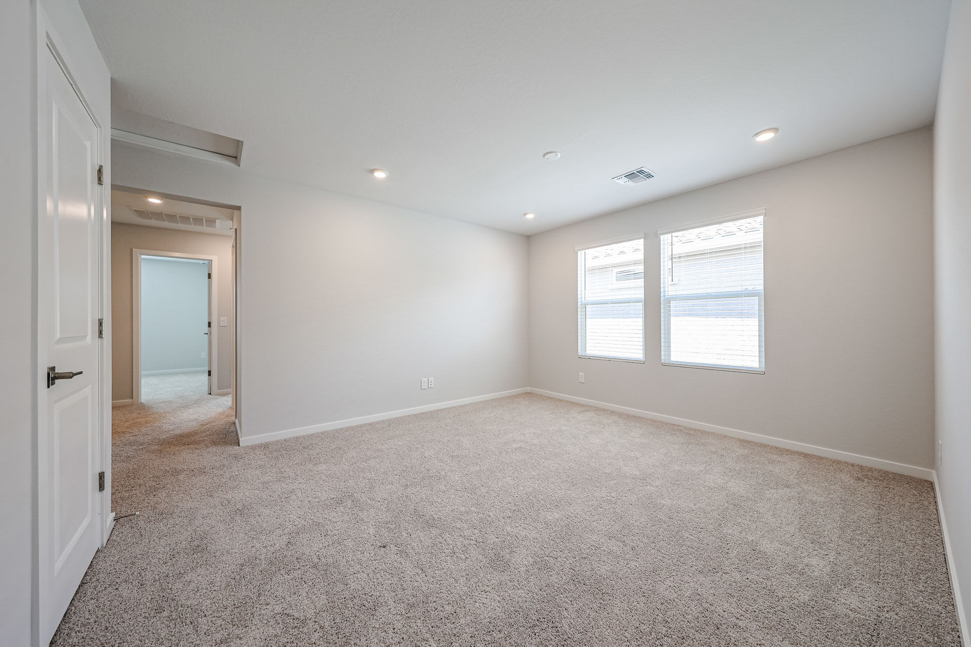 A room with a carpet and windows.