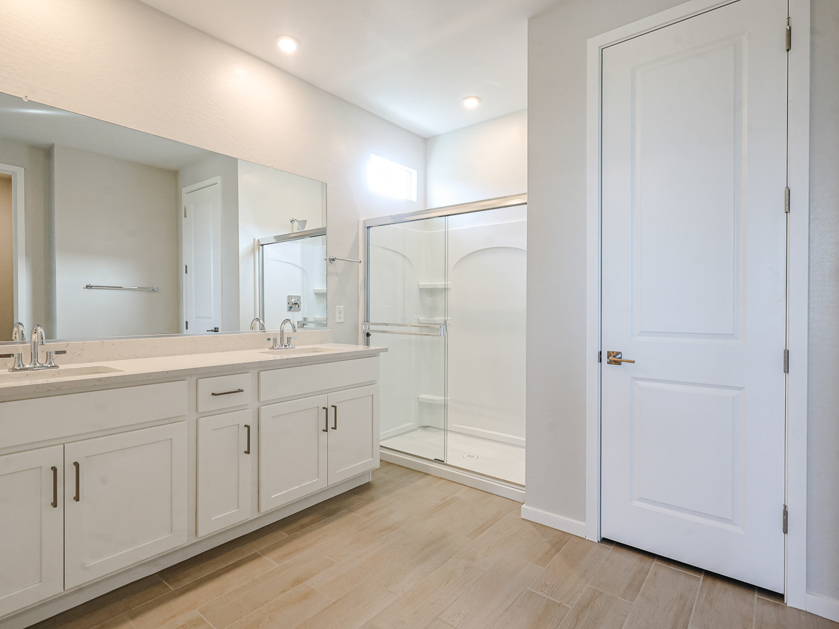 A bathroom with white cabinets.