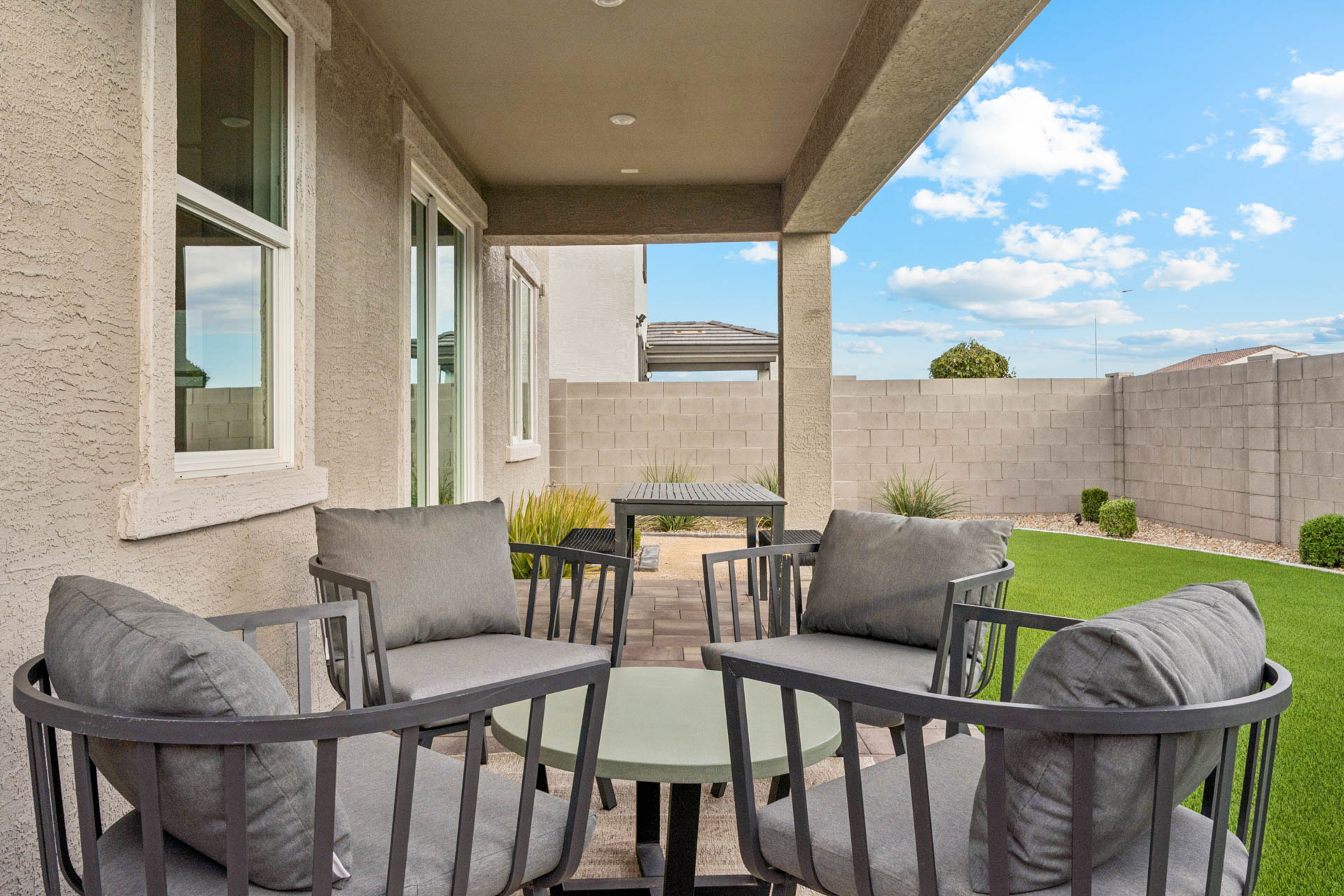 A patio with chairs and a table.