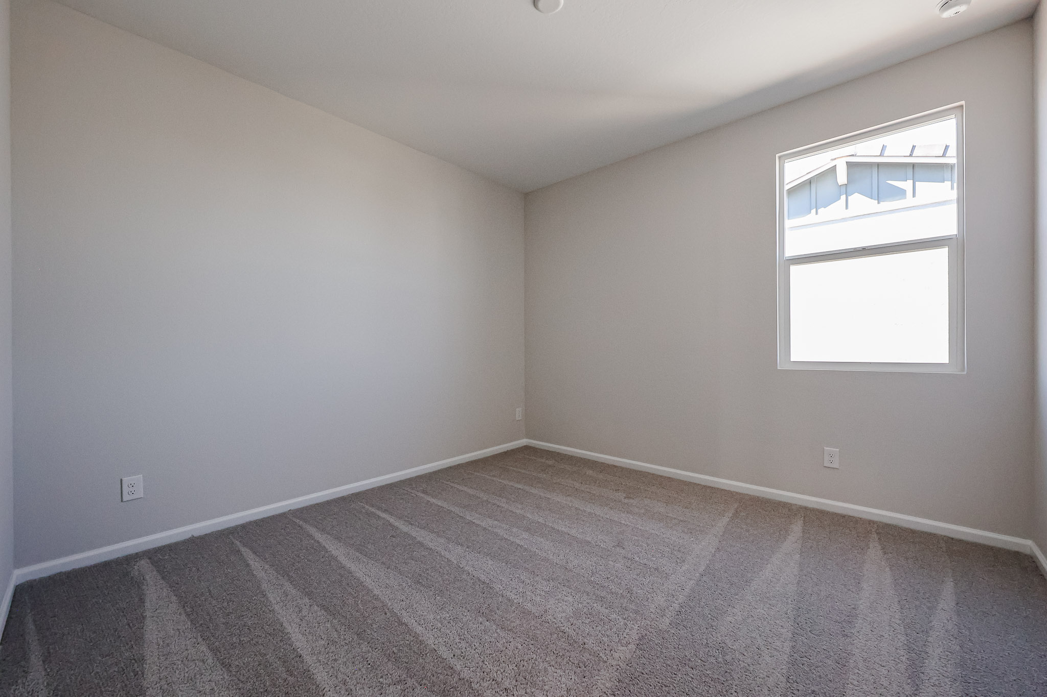 A room with a window and a carpet.