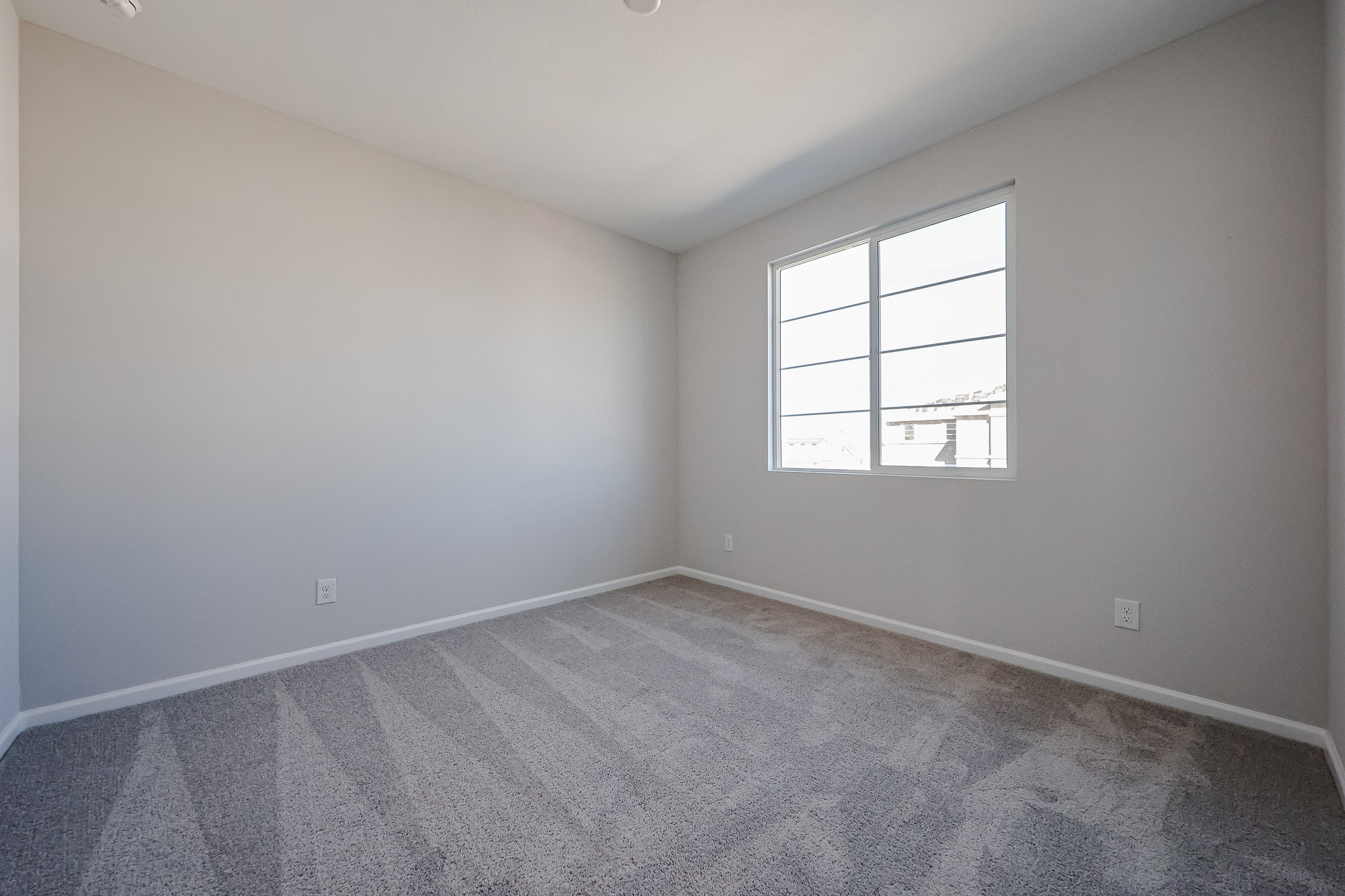 A room with a window and a carpet.