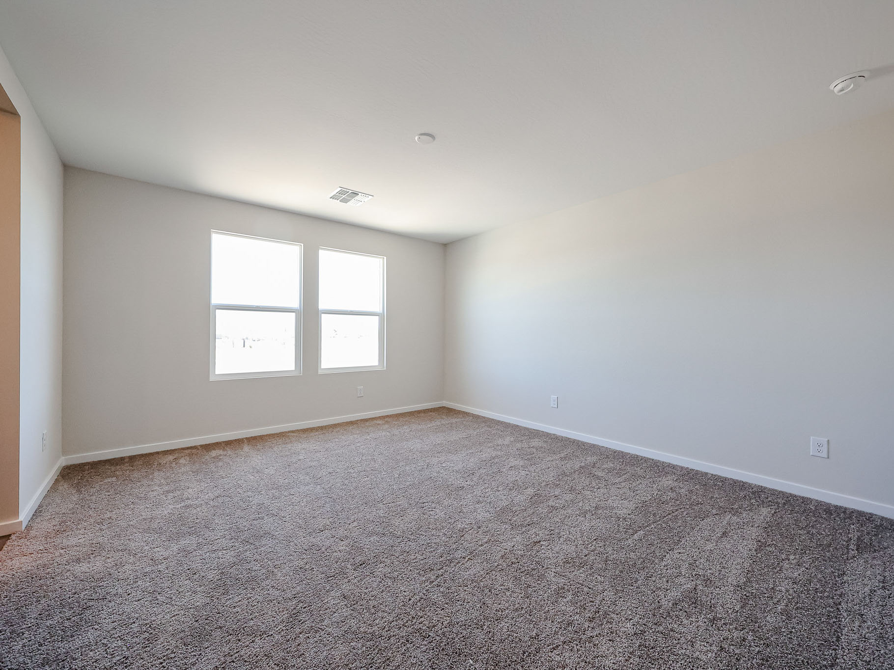 A room with a carpet and windows.