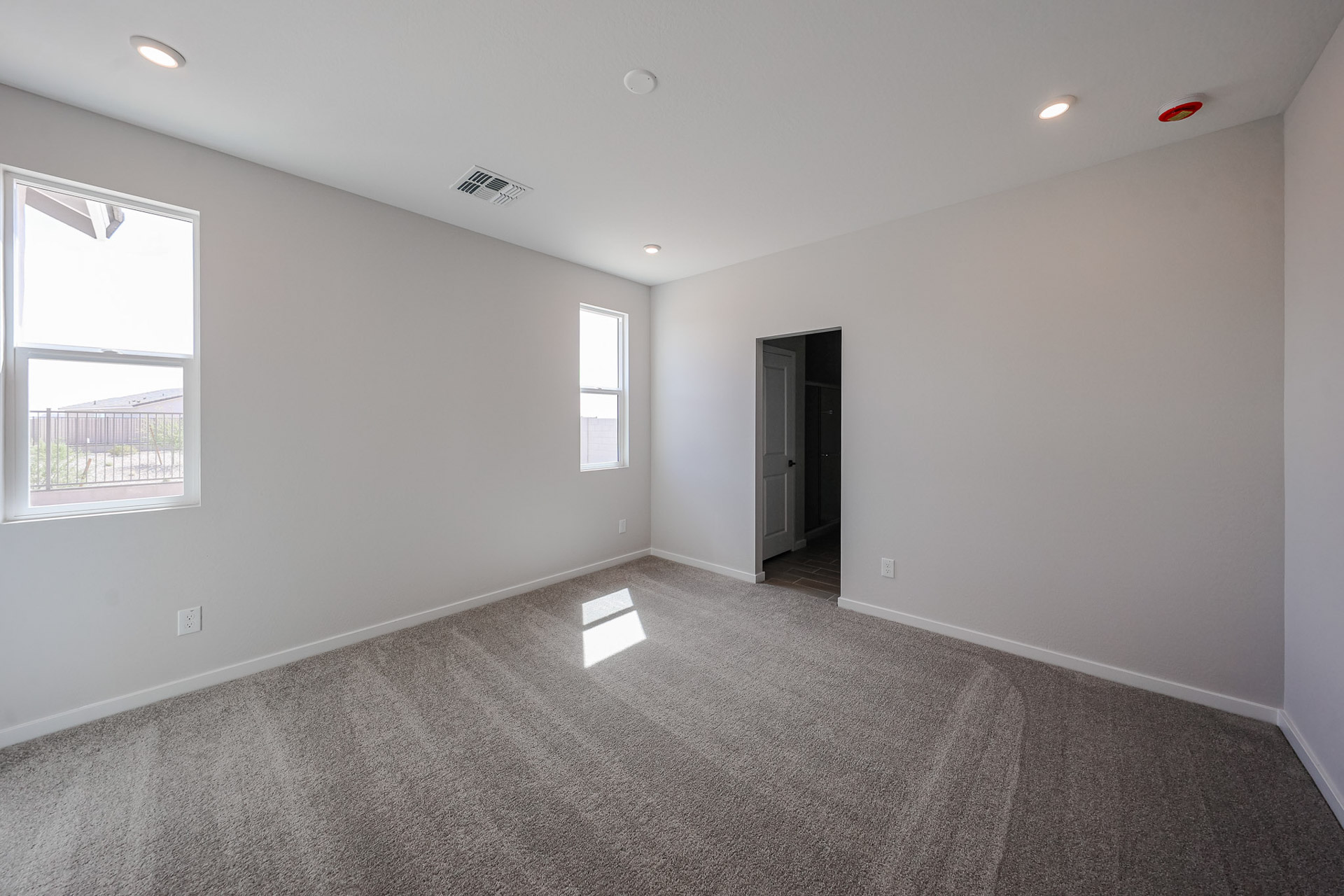 A room with a carpet and windows.