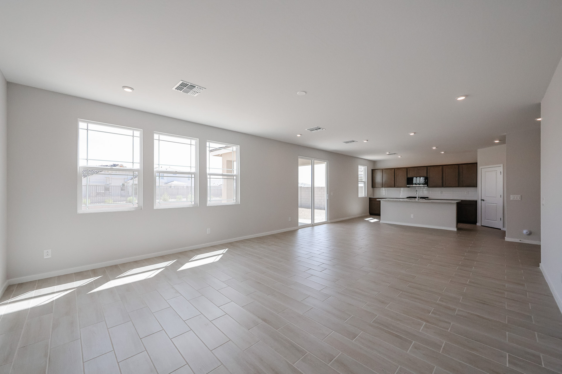 A large empty room with a wood floor and white walls.