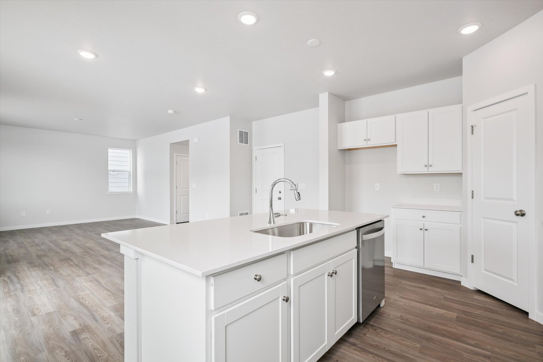 A kitchen with white cabinets.