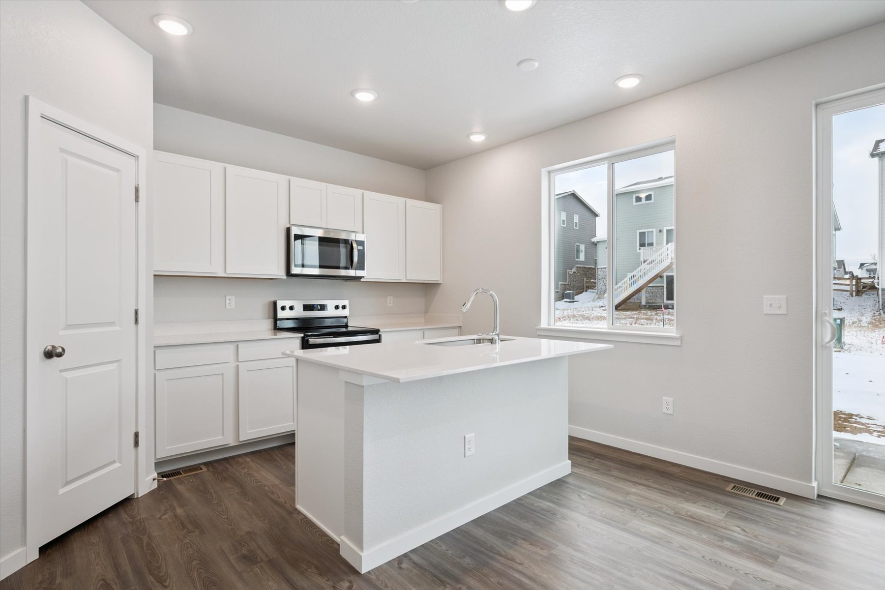 A kitchen with white cabinets.