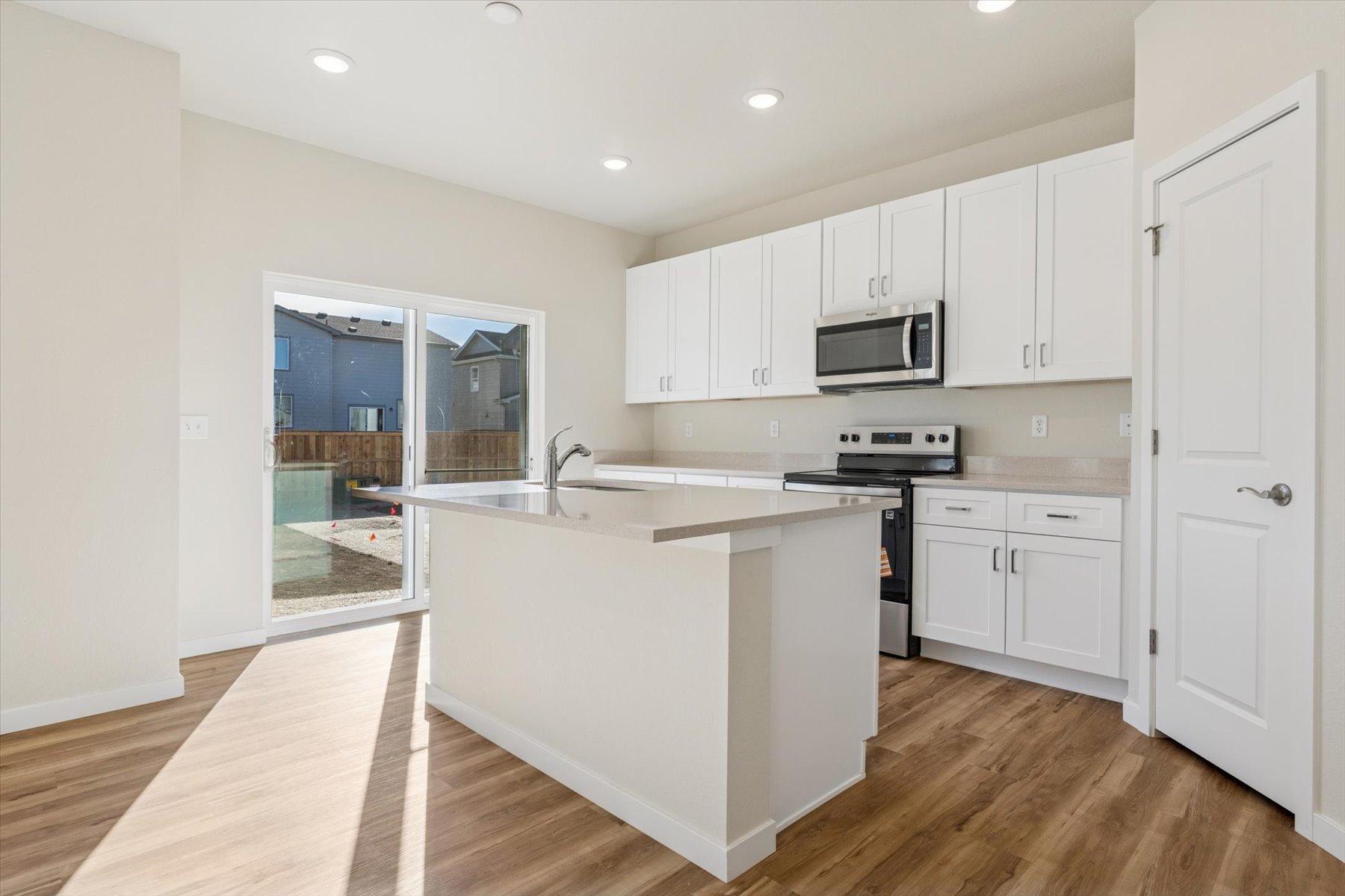 A kitchen with white cabinets.