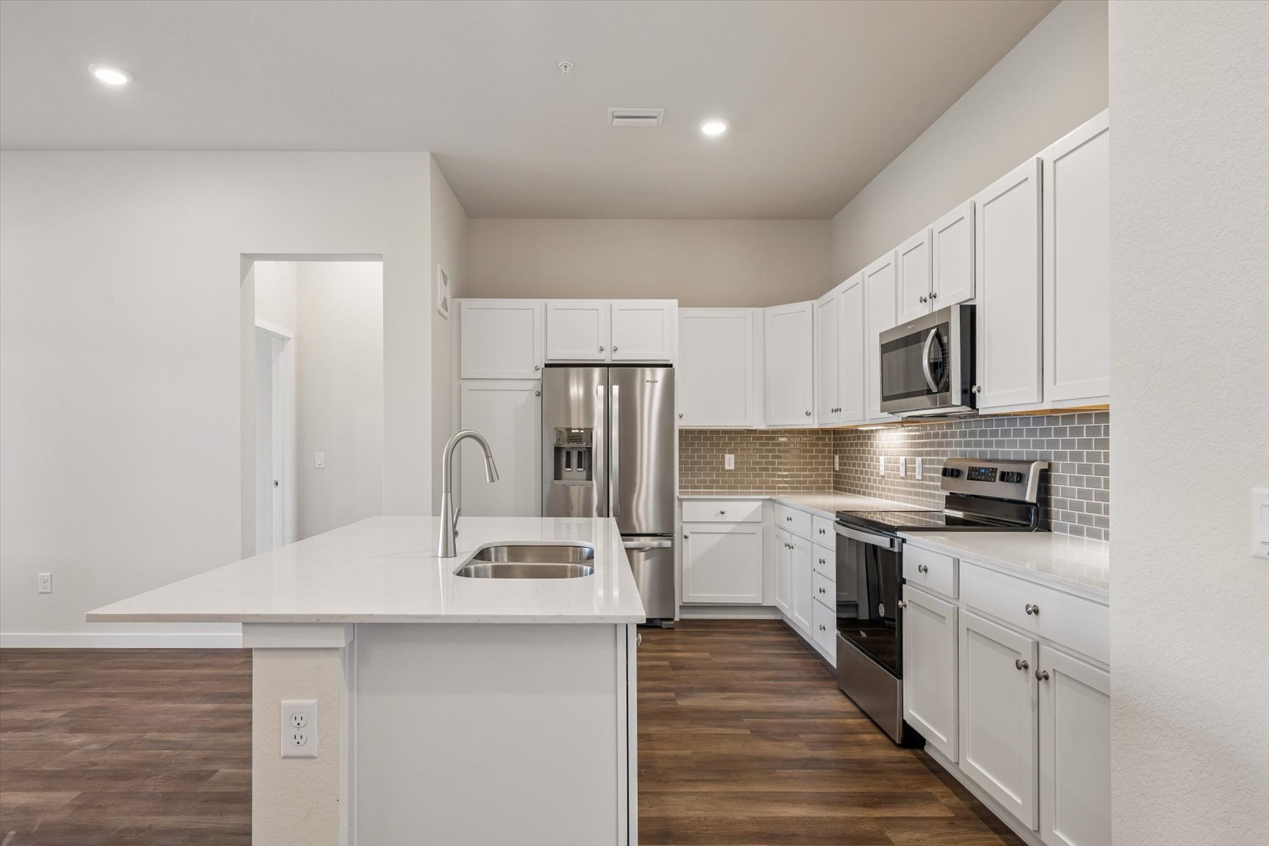 A kitchen with white cabinets.
