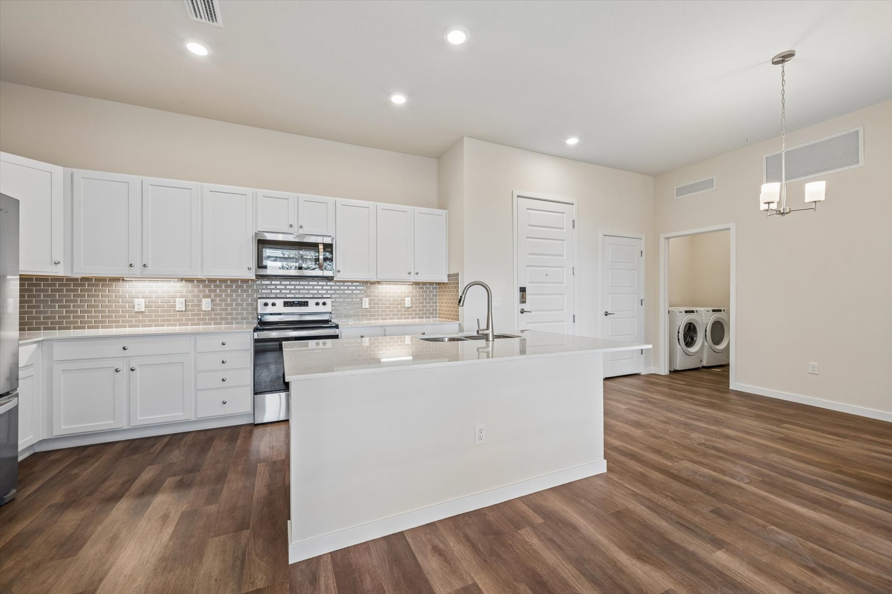 A kitchen with white cabinets.