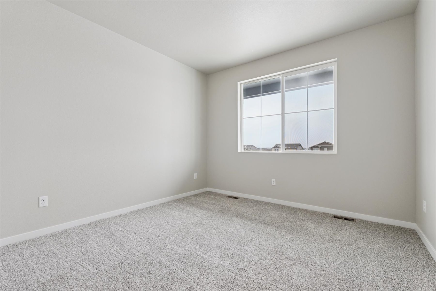 A room with a window and a carpet.