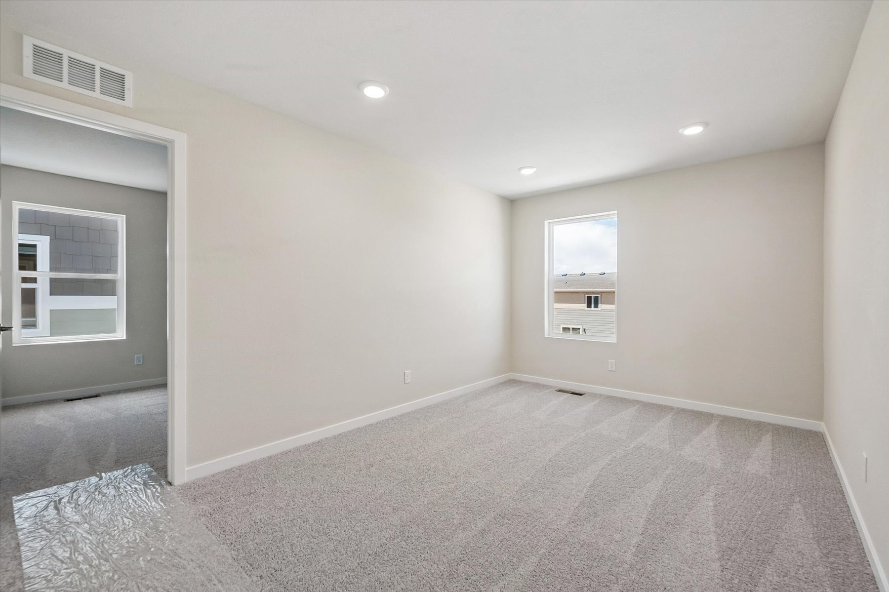 A room with a carpet and a window.