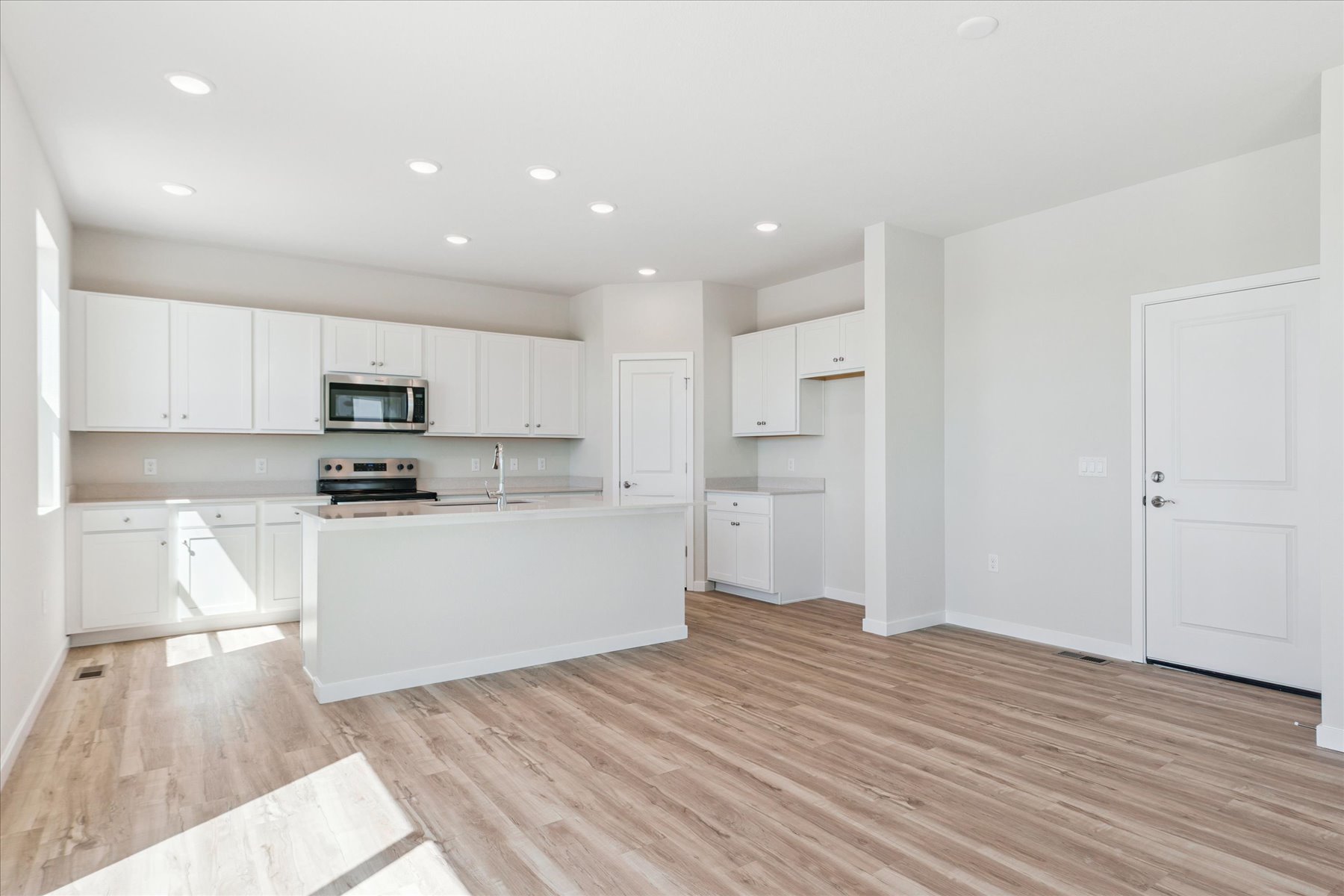 A kitchen with white cabinets.