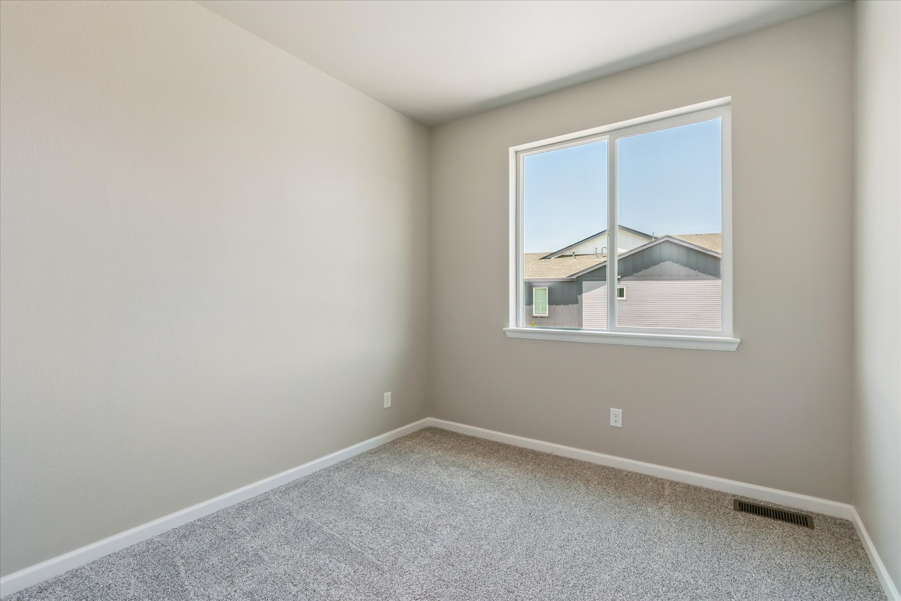 A room with a window and a carpet.
