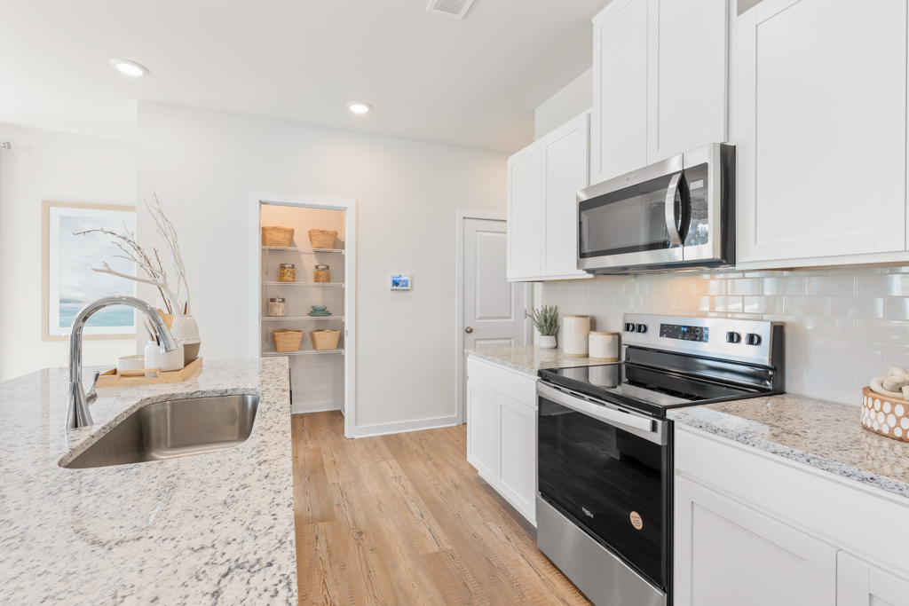 A kitchen with white cabinets.