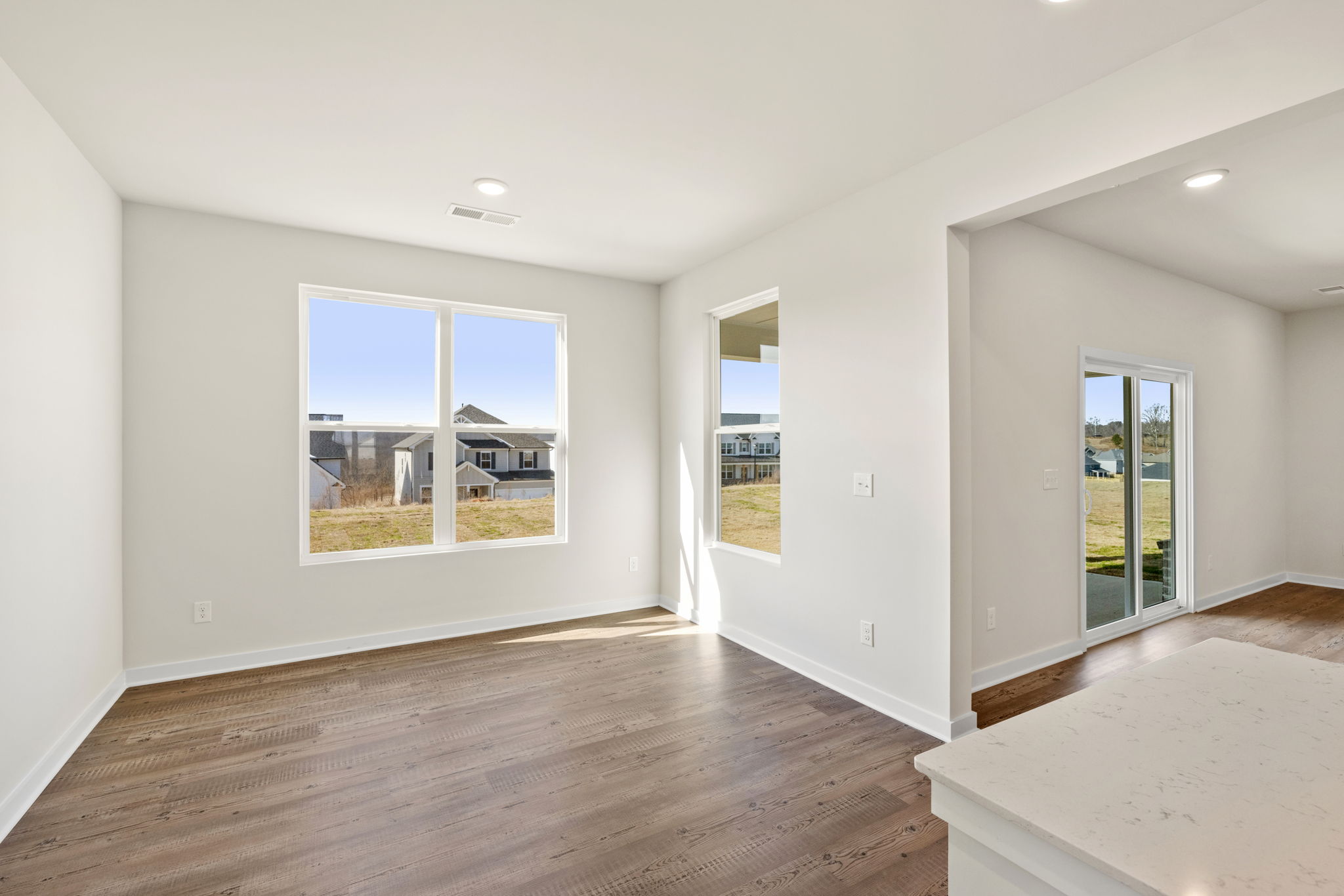 A room with a wood floor and a wood floor with a window.