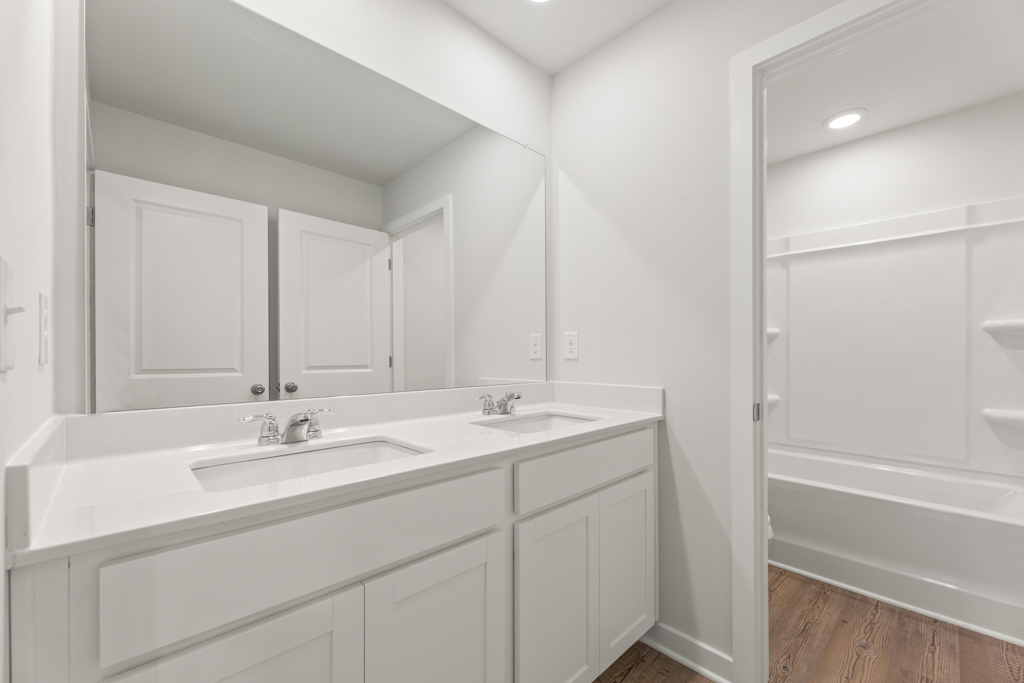 A bathroom with white cabinets.