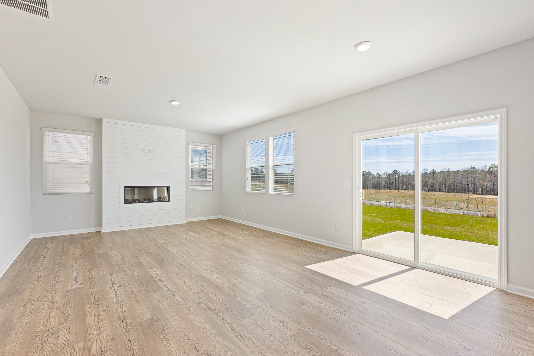 A room with a wood floor and a large window.