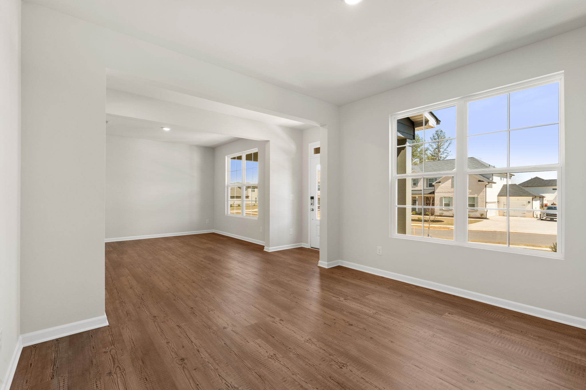 A room with a wood floor and a wood floor with a window.