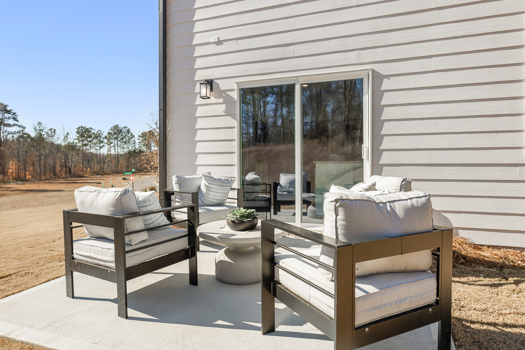 A deck with a chair and a table outside a house.