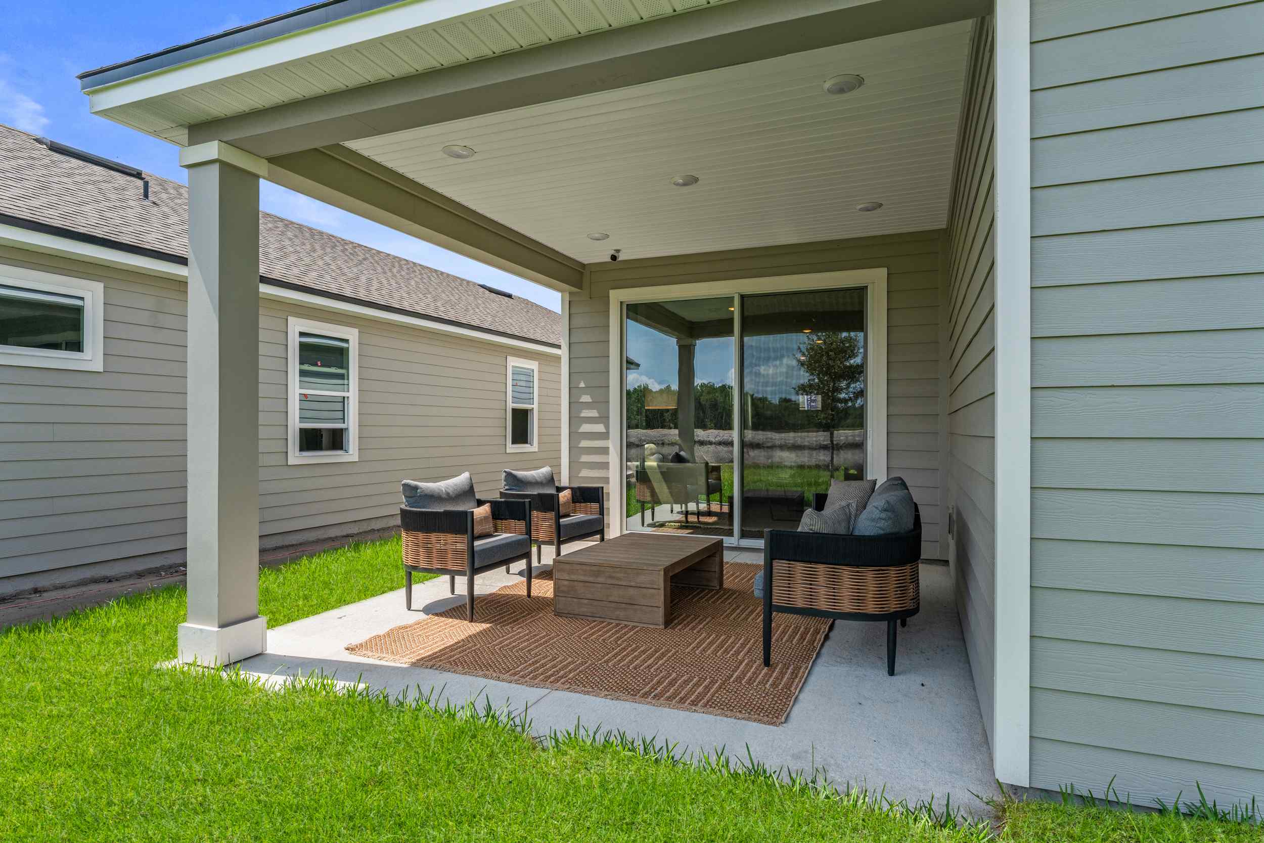 Silverbell II Model Home Covered Patio with Couch and Chairs at Camden Woods in Kingsland, GA