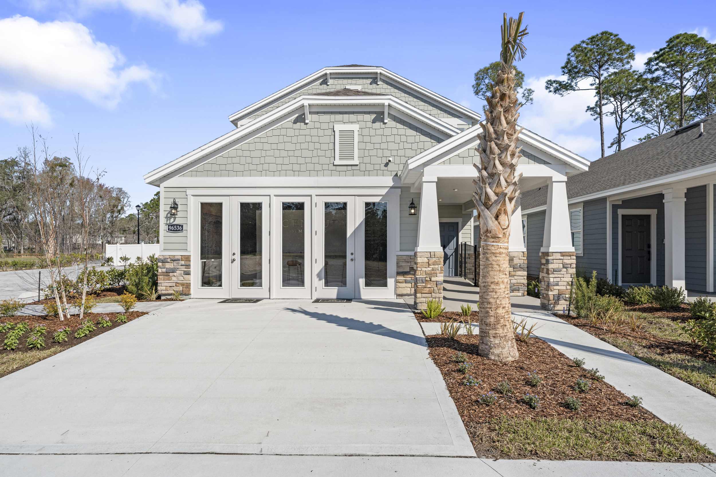 A white house with a tree in front of it.