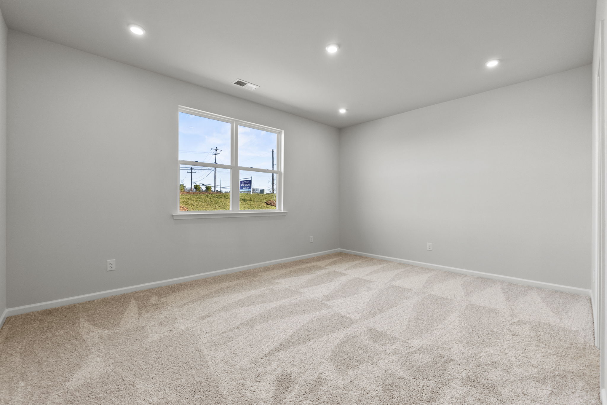 A room with a window and a carpet.