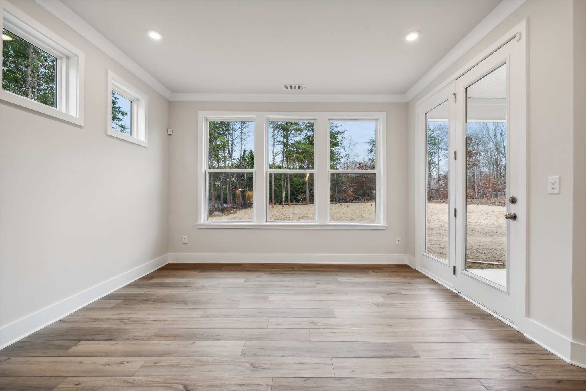 A room with a wood floor and windows.