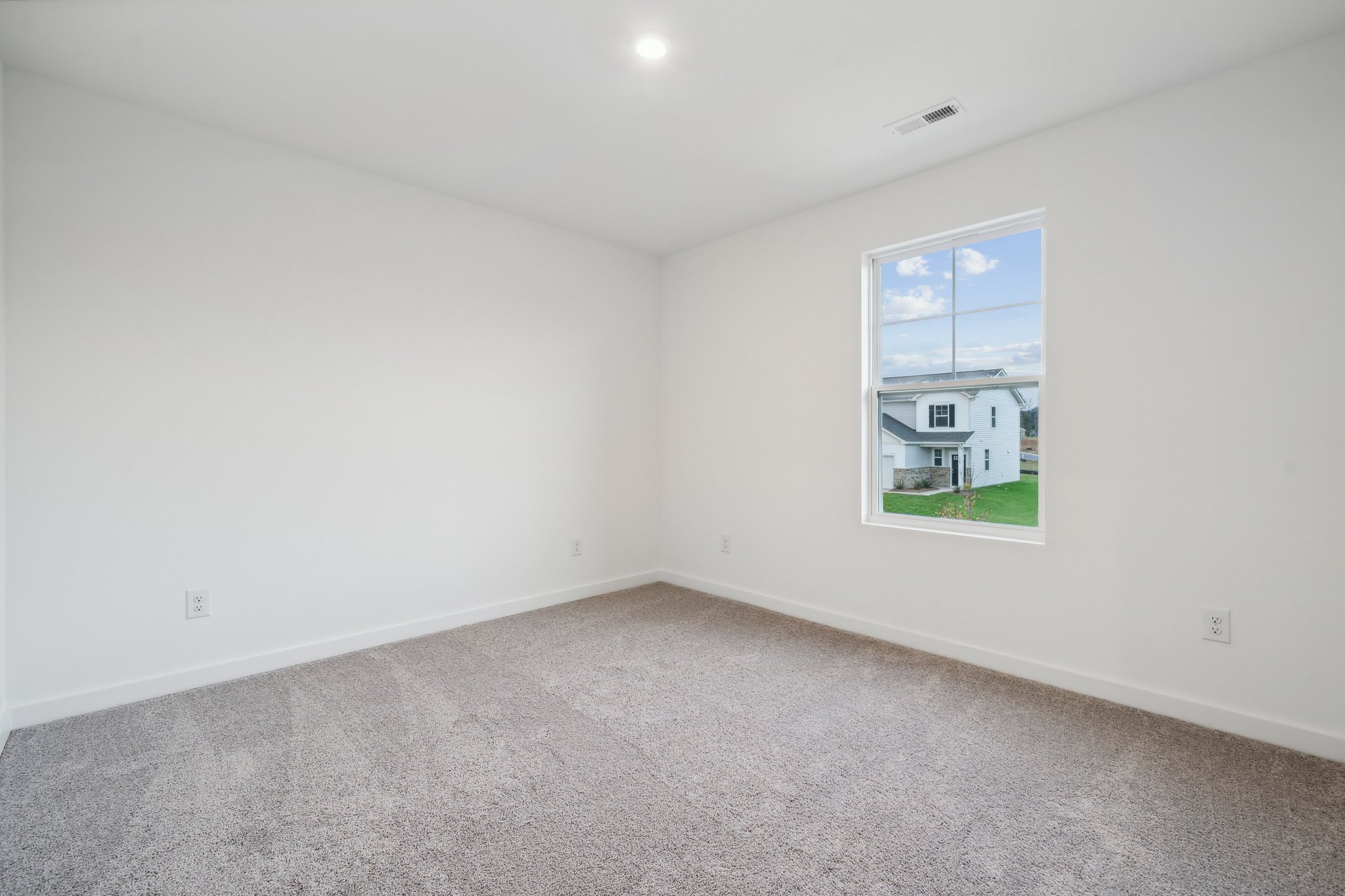 A room with a window and a carpet.