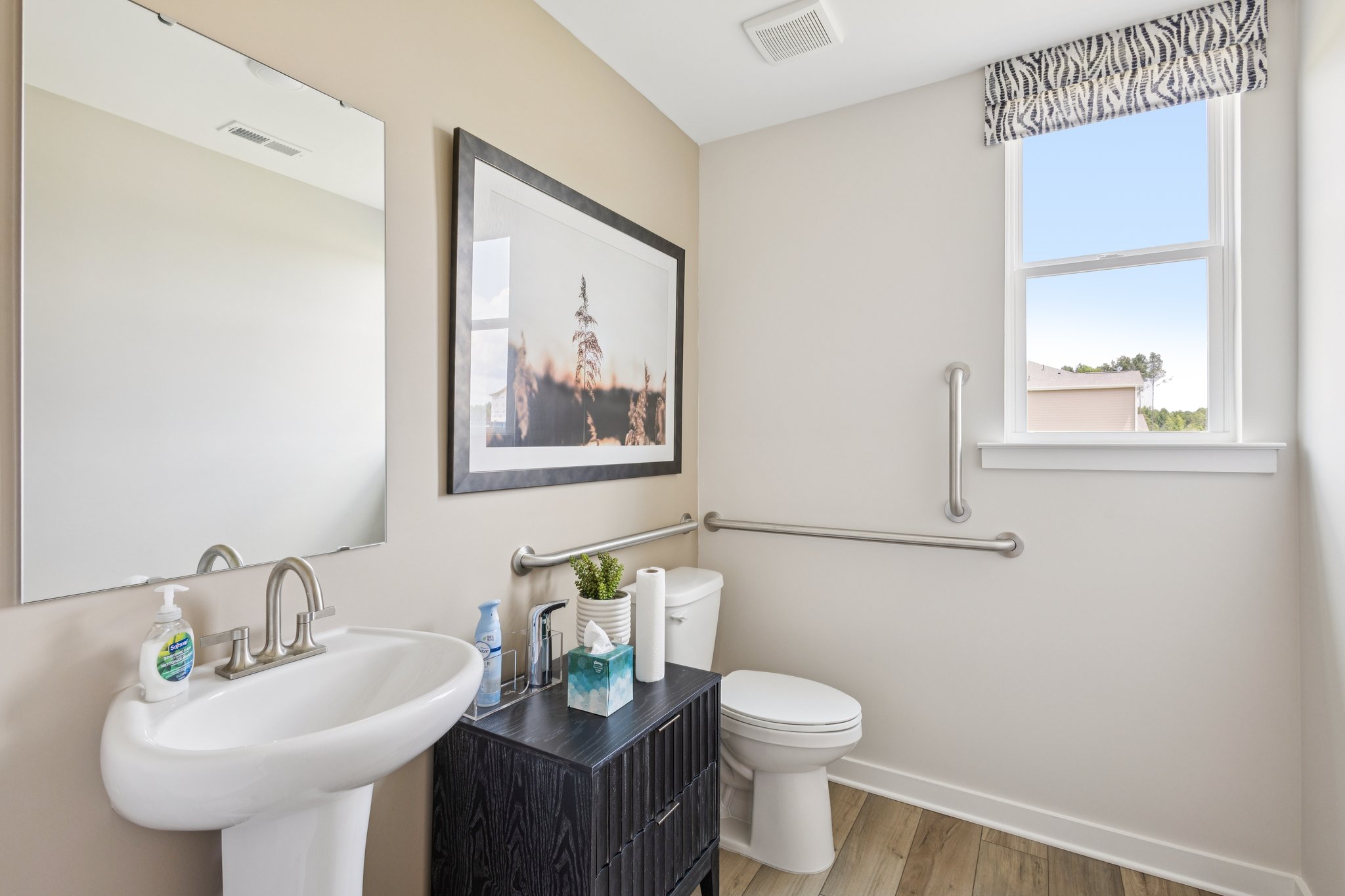 A bathroom with a sink toilet and a mirror.