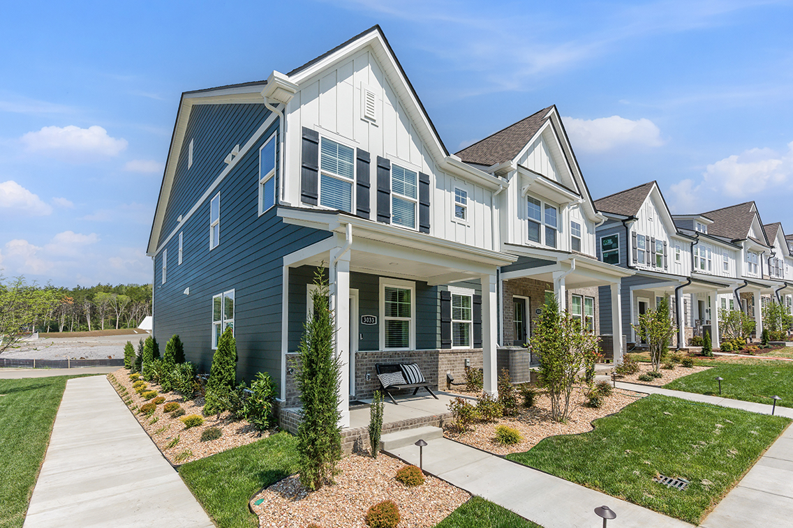 A large house with a lawn and a walkway.