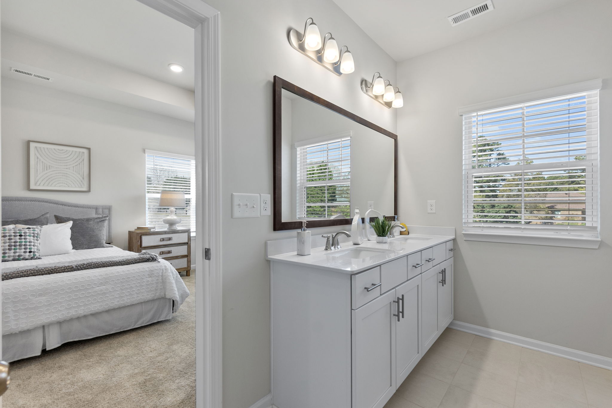 A bathroom with a sink and a bed.
