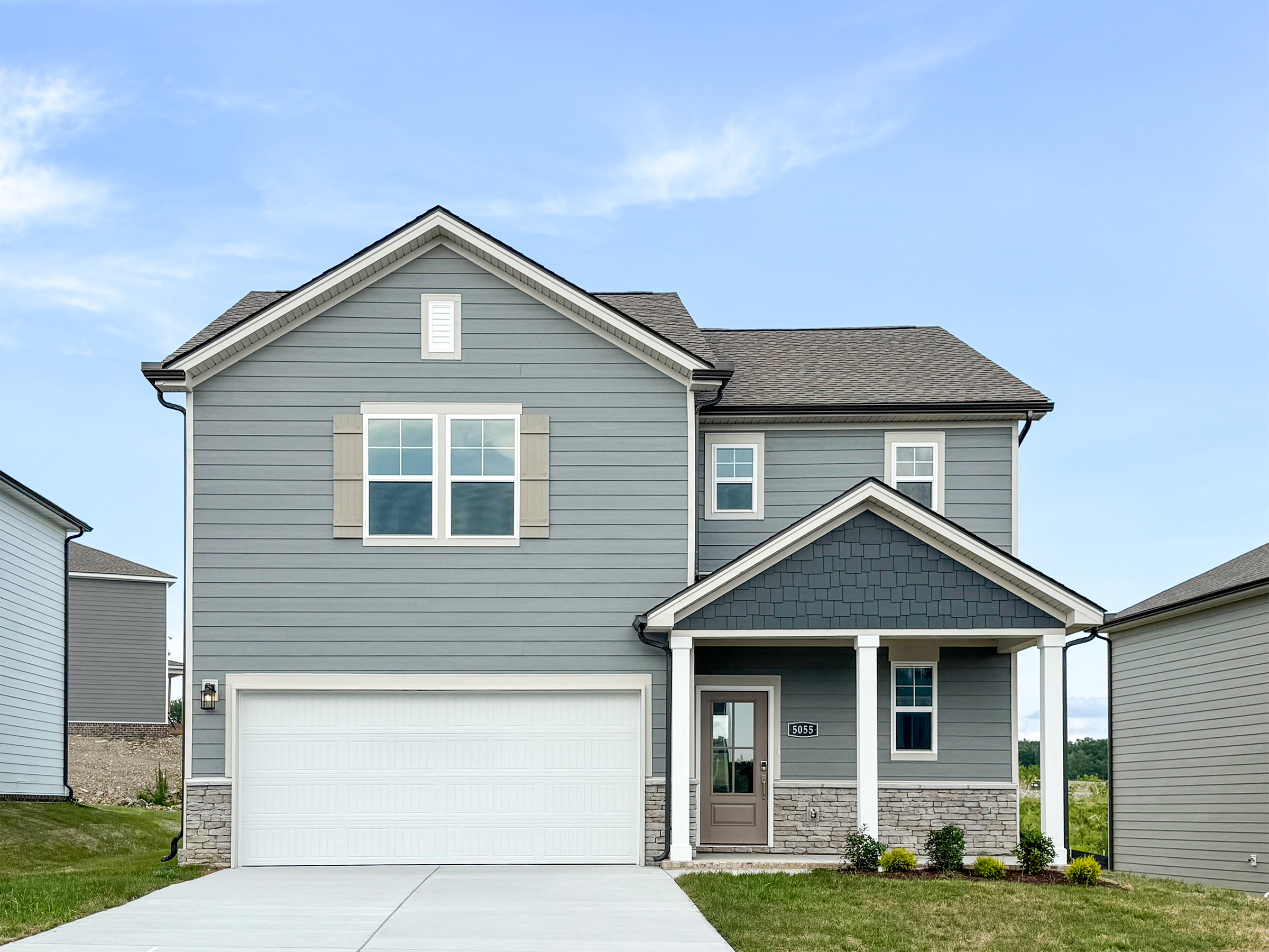 A grey house with a garage.