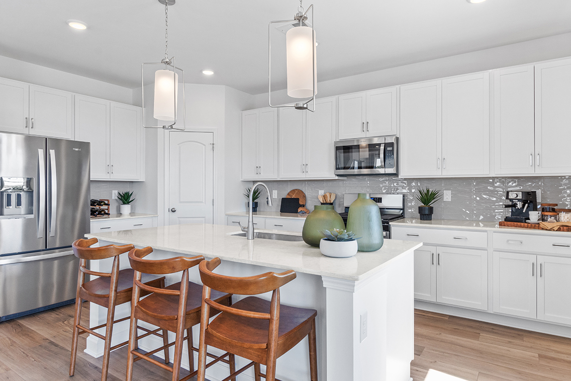 A kitchen with white cabinets.