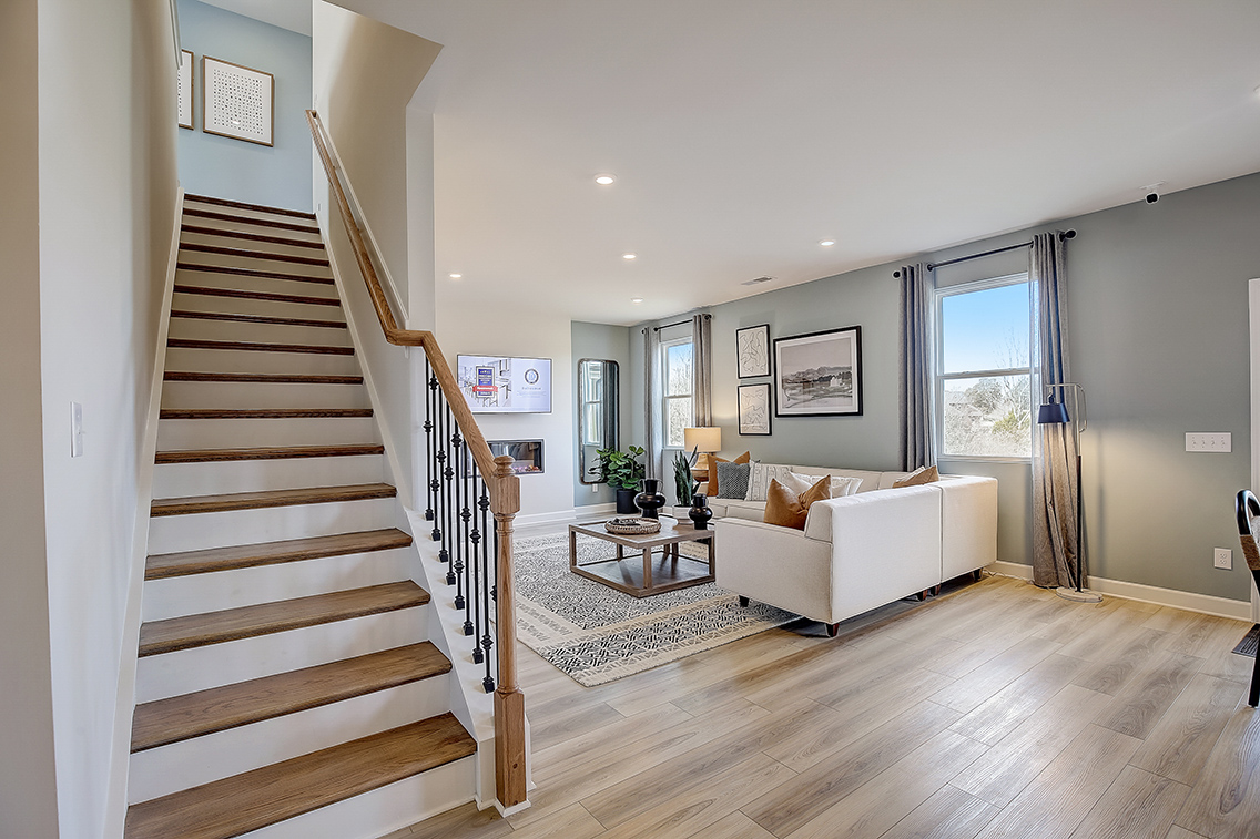 A large living room with a wood staircase.