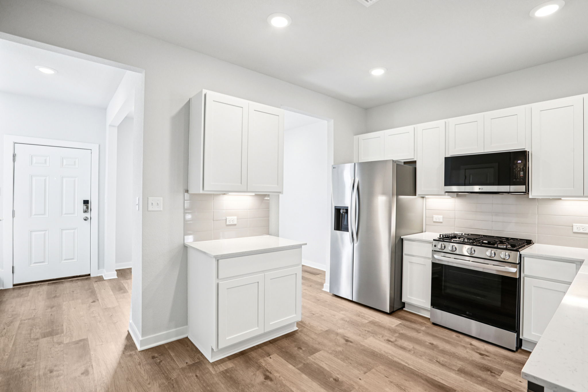 A kitchen with white cabinets.
