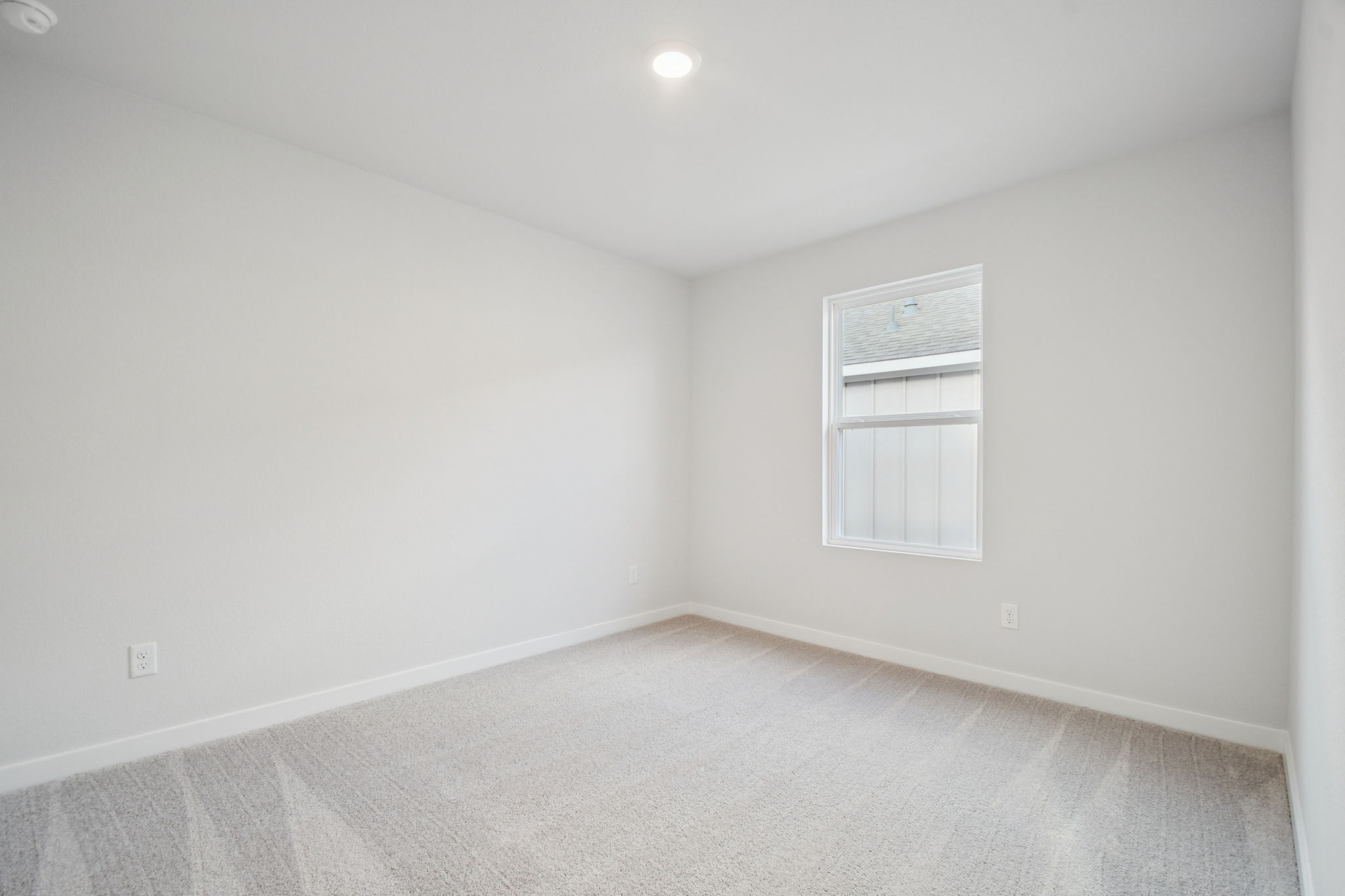 A room with a window and a carpet.