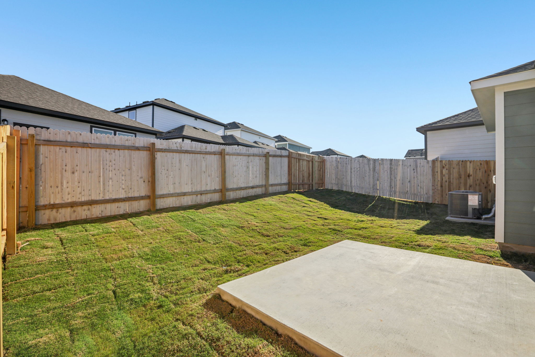 A fenced in yard with a house in the background.