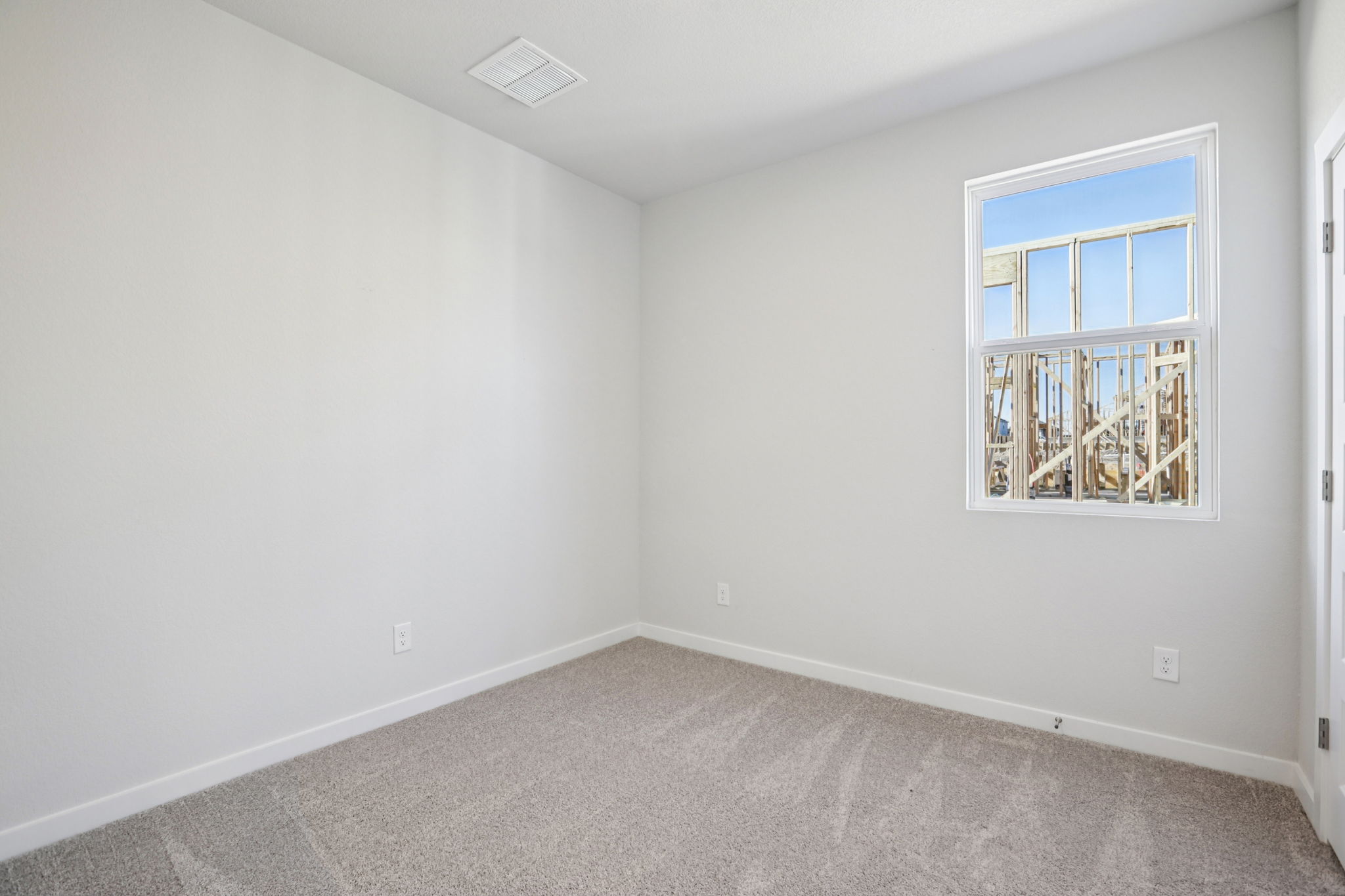 A room with a window and a carpet.