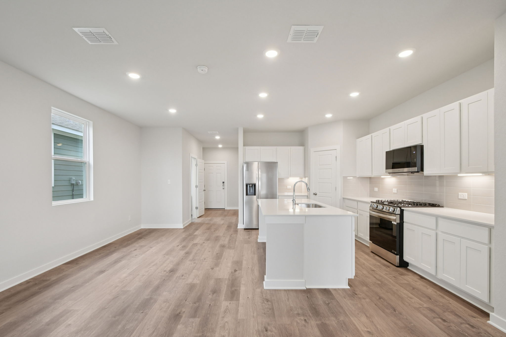A kitchen with white cabinets.