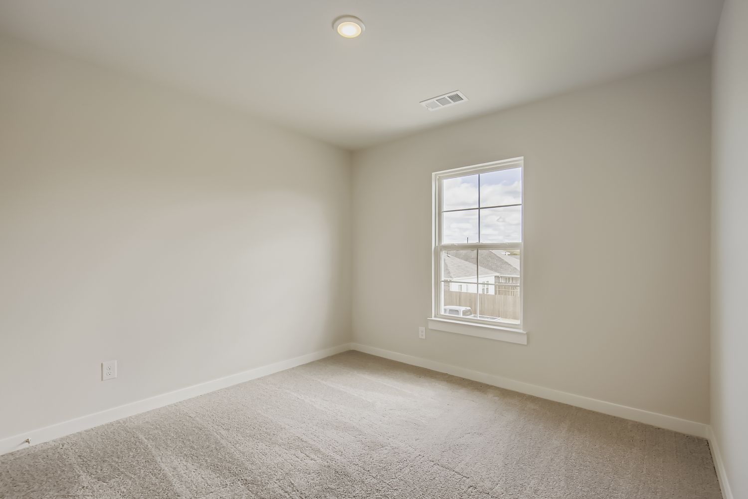 A room with a window and carpet.