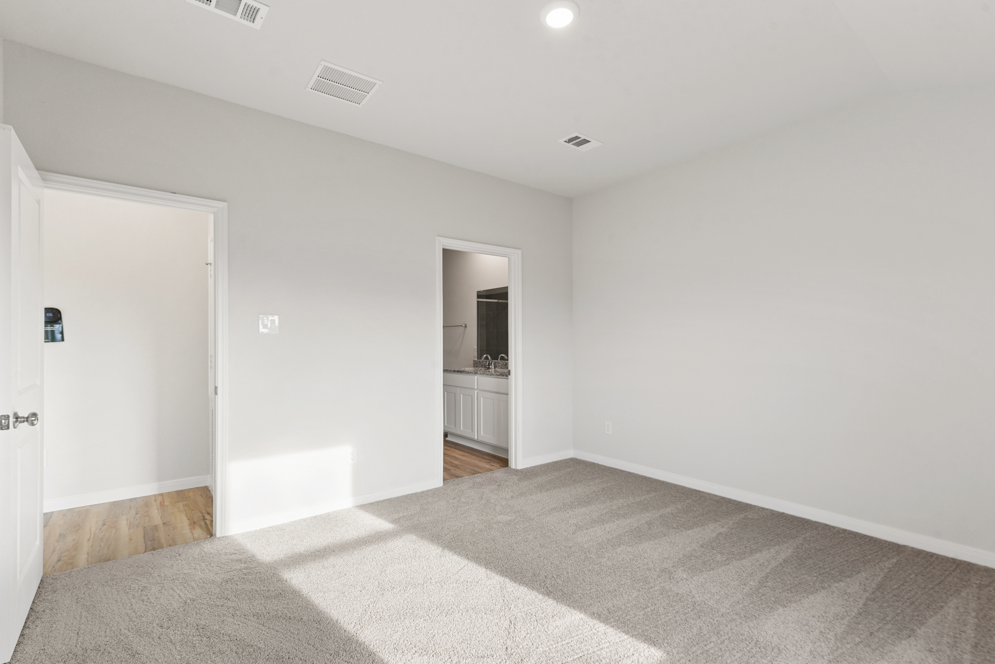 A room with a carpet and a door.
